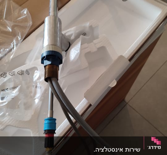 ברז מטבח עם צינורות חיבור על קרטון